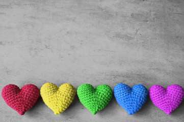 Valentine's Day. multicolored knitted hearts on a grey background. Flat lay.