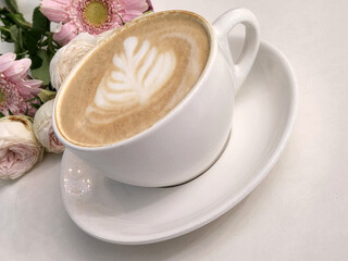 Cup of hot coffee with a bouquet of flowers. Coffee and flowers