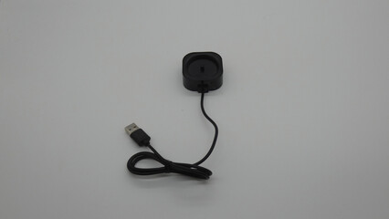 USB charger with plug and cable on a plain surface for electronic device charging purposes