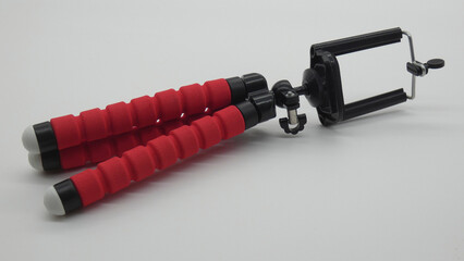 Tool for taking selfies with red grips and adjustable holder for smartphones in October
