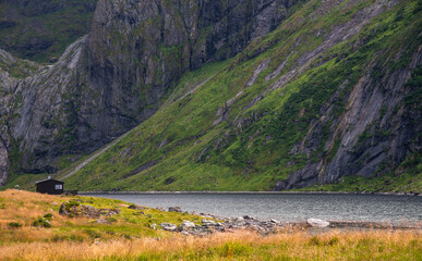 Remote cabin by mountain lake in nordic landscape