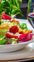 Salad with lettuce, sun-dried tomatoes, and toasted bread with grated Parmesan cheese.