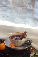 A mug of hot black tea on the windowsill. Christmas atmosphere.