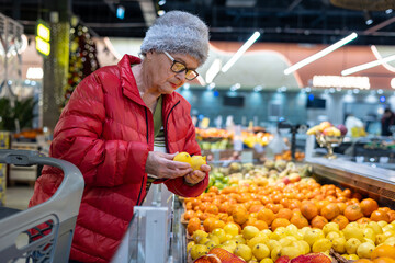 Elderly Woman Choosing Fresh Lemons at Supermarket Produce Section – Active Senior Lifestyle, Healthy Eating and Independent Shopping