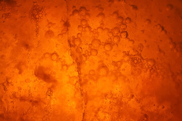 Ice texture. Frozen bubbles in ice. Orange grunge abstraction