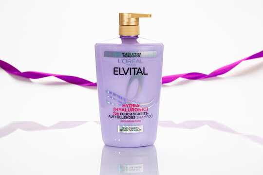 L&rsquo;Or&eacute;al Elvital Hydra Hyaluronic shampoo bottle photographed in studio with white background and purple ribbon detail, showing product packaging and branding for beauty and haircare context.