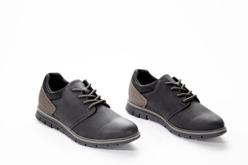 Pair of black and gray casual men’s shoes photographed in studio on a white background, showing modern footwear design, materials, and style for fashion or retail use.