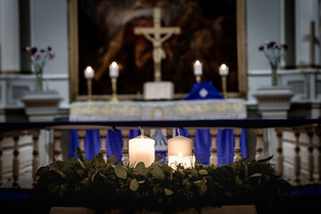 Advent Wreath with Burning Candles before Church Altar and Crucifix during Worship Season