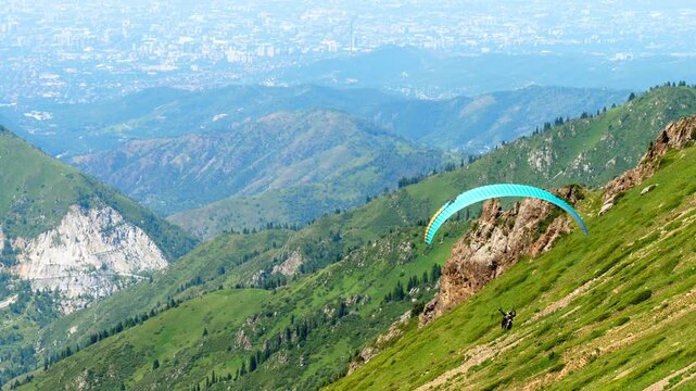A paraglider soars over a stunning mountain landscape. Concept freedom of extreme sports and adventure