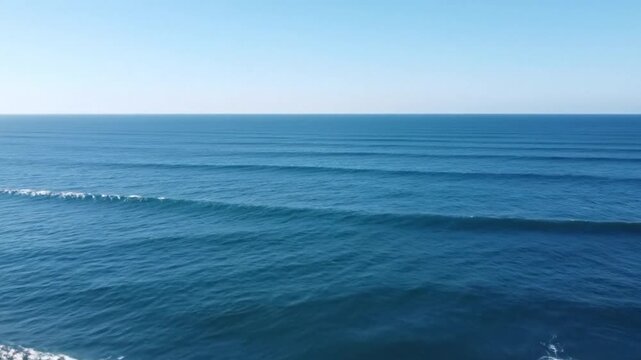 Aerial Wide Shot of Endless Blue Ocean Swell Lines Rolling Rhythmically Under Clear Sky