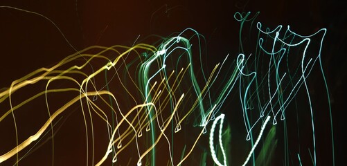 Abstract neon light trails. Long exposure. Dark motion blur background with copy space.