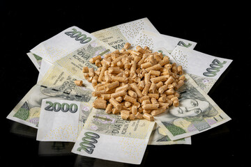 Bulk Wood Pellets On Scattered Koruna Notes Conveying Wholesale Purchase, Supply Chain And Vendor Cost Negotiation, Fan Of Banknotes Framing Dense Pellet Pile With Studio Lighting And Sharp