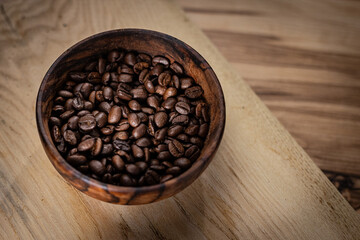 A detailed close-up view of freshly roasted coffee beans in a bowl, showcasing their rich color and texture