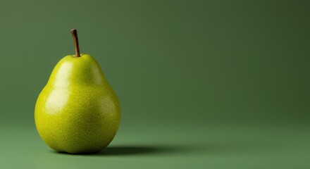 A perfectly ripe green pear rests on a smooth, monochromatic green background, highlighting its natural curves and vibrant color ,solid, agriculture, ripe