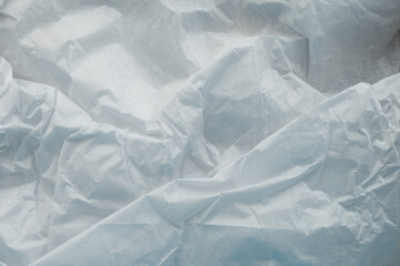 Crumpled white paper on a flat surface in bright light during the day