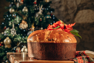 traditional Italian Christmas bread Panettone cake with sparkling wine or champagne in elegant glasses on a decorated table for a festive lunch or dinner, New Year Christmas food tradition