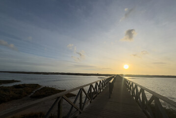 Naklejka premium Wooden walkway on a beach at sunset