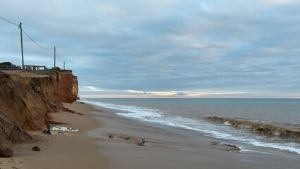 What a sandy beach on the Atlantic. Landscape shot at sunset of a coast with sandstone cliffs. Low...