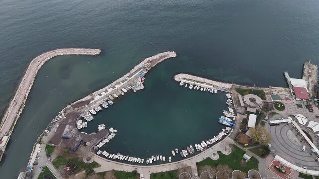 Footage of a coastal city marina featuring yachts, boats, and waterfront infrastructure. The scene highlights maritime lifestyle, tourism, leisure activities, and modern coastal urban development, re