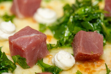 Close-up of gourmet pizza on red background highlighting texture and ingredients