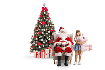 Girl with a unicorn standing next to Santa claus seated in armchair