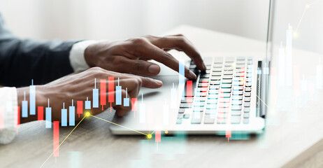 A person is concentrating on typing on a laptop in a well lit office space. The environment is bright and calm, promoting productivity during work hours.