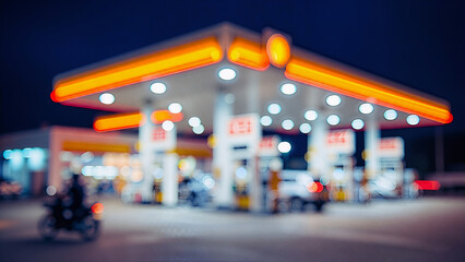 Blurred Night Scene at a Brightly Lit Fuel Station with Vehicles and Glowing Bokeh Effects