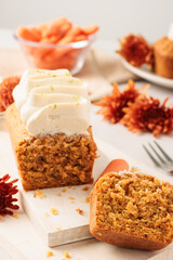 Homemade Carrot Cake Loaf with Cream Cheese Frosting on Rustic White Board