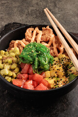 Colorful Poke Bowl with Fried Chicken, Fresh Fruits, Seaweed Salad, and Chopsticks