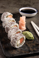 Assorted Sushi Rolls with Creamy Topping on Slate Plate and Chopsticks