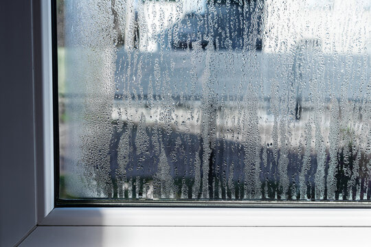 Drops of condensation on the metal-plastic window. Fragment of a plastic window with water condensation on the glass, temperature difference, humidity in the room, humidity problem. 