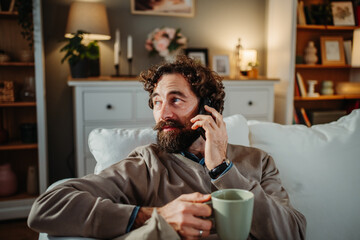 Man talking on phone, relaxing at home with coffee