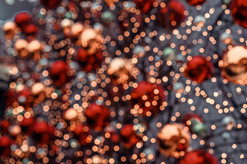 Bokeh and Christmas balls. Defocused Christmas lights with red and gold ornaments create festive bokeh background. Concept of holiday magic, Christmas atmosphere and winter celebration sparkle