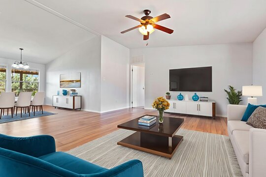 Living room with couch, chair, table, TV, and ceiling fan