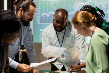 Enterprise advisory board meeting late at night to assess risks and exchange feedback, collaborating on project insights backed by business intel and performance metrics diagrams. Work team.
