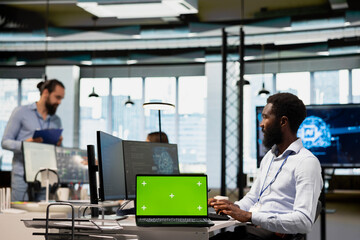 Engineer in office using AI on green screen laptop to streamline app development. IT expert using mockup notebook to run debugging applications with machine learning technology
