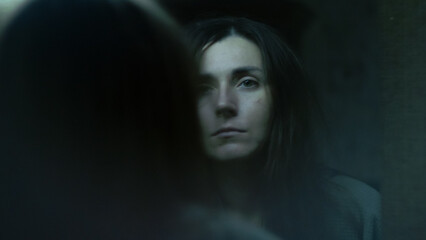 A young woman stares at her reflection in the mirror with confusion and disappointment. A tense emotional moment showing self-doubt, inner struggle, and vulnerability. 