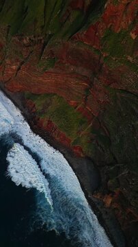 Sunset on the cliffs of Ponta do Tristan. Aerial view of ocean waves crashing against rocky coastline