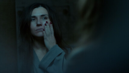 A young woman stares at her reflection in the mirror with confusion and disappointment. A tense emotional moment showing self-doubt, inner struggle, and vulnerability. 