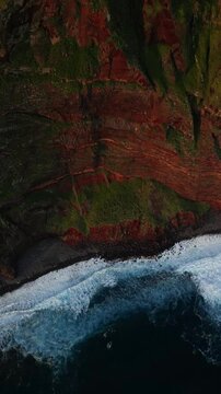 Sunset on the cliffs of Ponta do Tristan. Aerial view of rugged coastline with waves crashing below