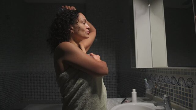 Young conscious woman applying a natural crystal deodorant antiperspirant from alum salts to her armpits to reduce odor and sweat. Eco-friendly and organic cosmetics for health and wellness