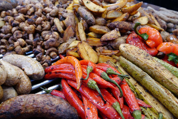 Various fried hot foods. Hot peppers, zucchini, potatoes, sausages and mushrooms