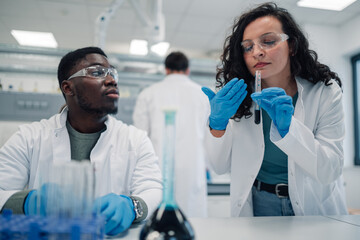 Diverse scientists conducting chemistry research experiment in laboratory