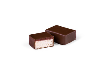 A candy with soufflé filling covered in chocolate on a white background