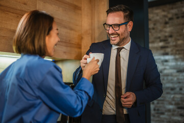 Business colleagues laughing and having coffee break discussion