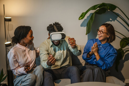 Diverse friends enjoying virtual reality experience and laughing together - Powered by Adobe