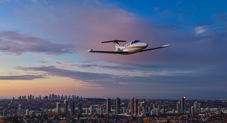 Private Jet Over City Skyline at Sunset: Airplane Flight Over Burnaby, BC, Canada