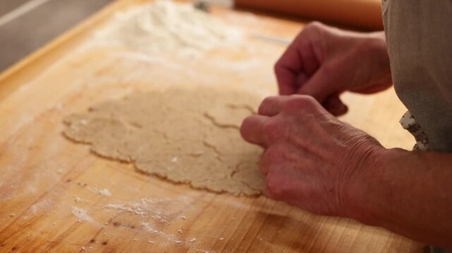 Hands cutting cookie shapes from rolled dough showing real Christmas baking preparation