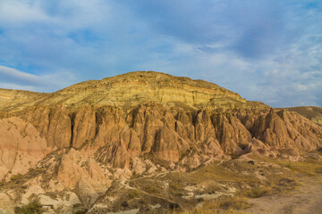 Fototapeta premium Cappadocia valley in Turkey. Cappadocia rock formation sites and chimneys Love Valley. Tuff volcanic rock pillars and mushrooms in the museum under open sky in Cappadocia turkish famous tourist sight
