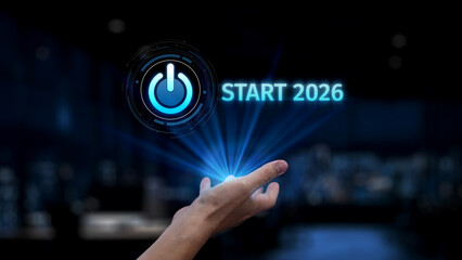 A futuristic hand gesture activates a glowing power button icon, symbolizing the start of 2026....